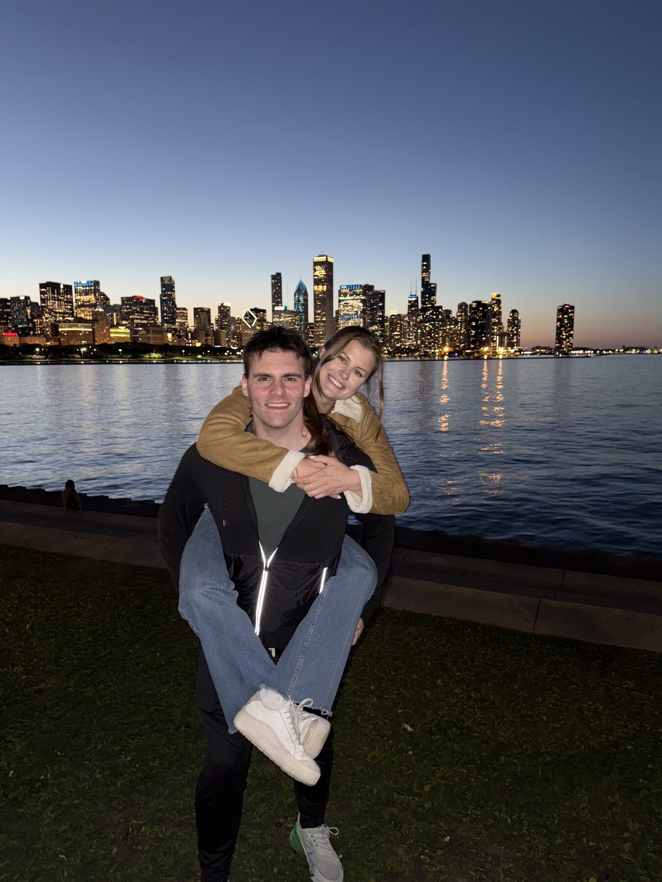 Tom giving Anna a piggyback with the Chicago skyline behind them