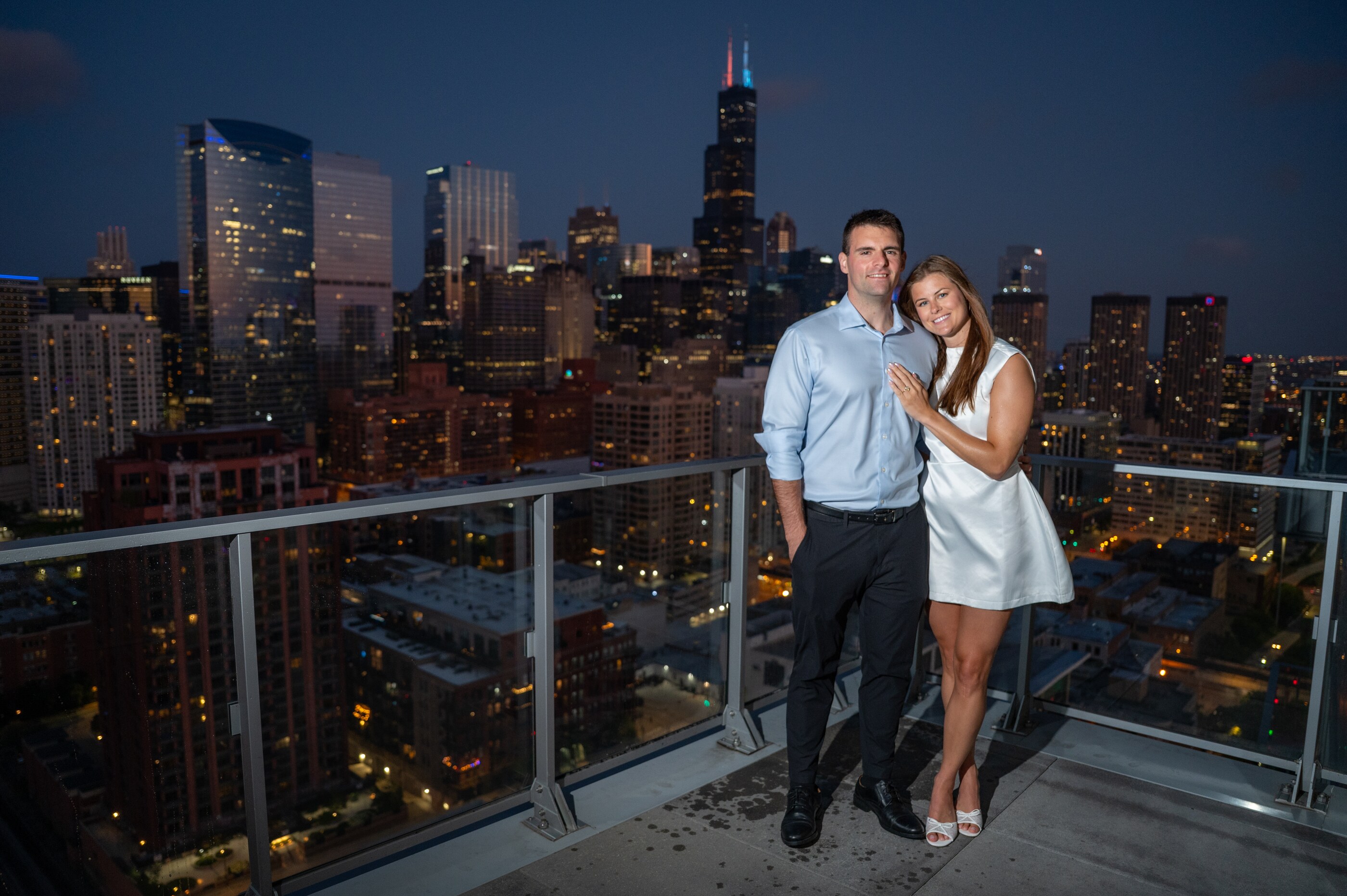 Tom and Anna on a rooftop with the Chicago skyline at night
